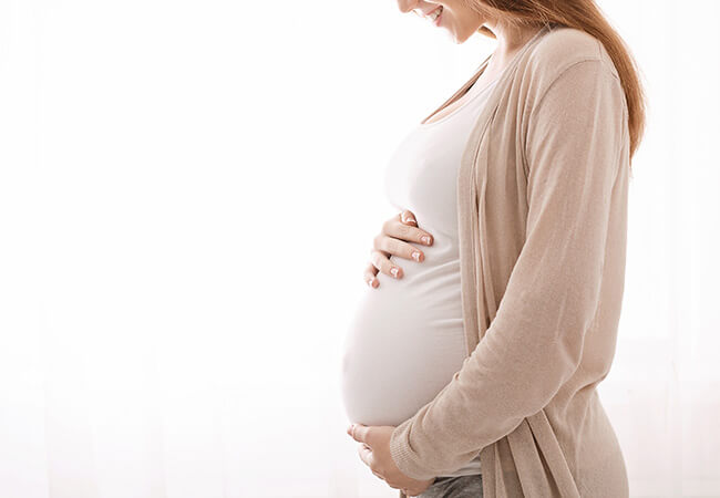 Pregnant person holding stomach