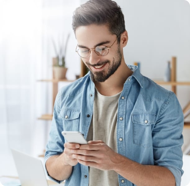 Man smiling looking down at mobile phone