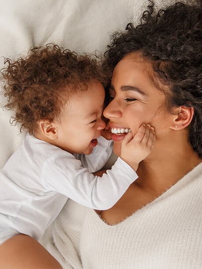 Parent cuddling baby in bed